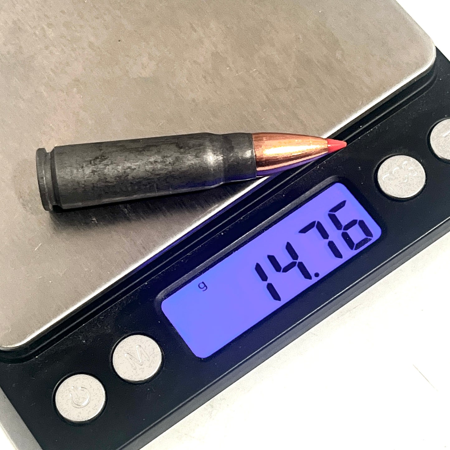 Steel 7.62x39 dummy round with a red-tipped bullet on a digital scale reading 14.76 grams