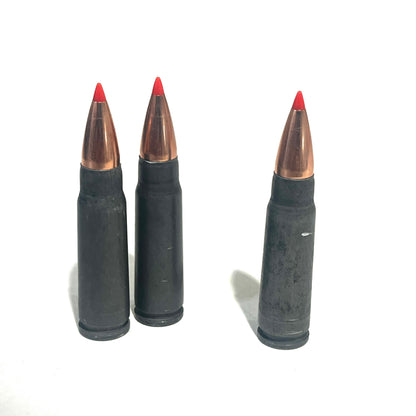 3 steel 7.62x39 dummy rounds with red-tipped bullets standing upright on a white background