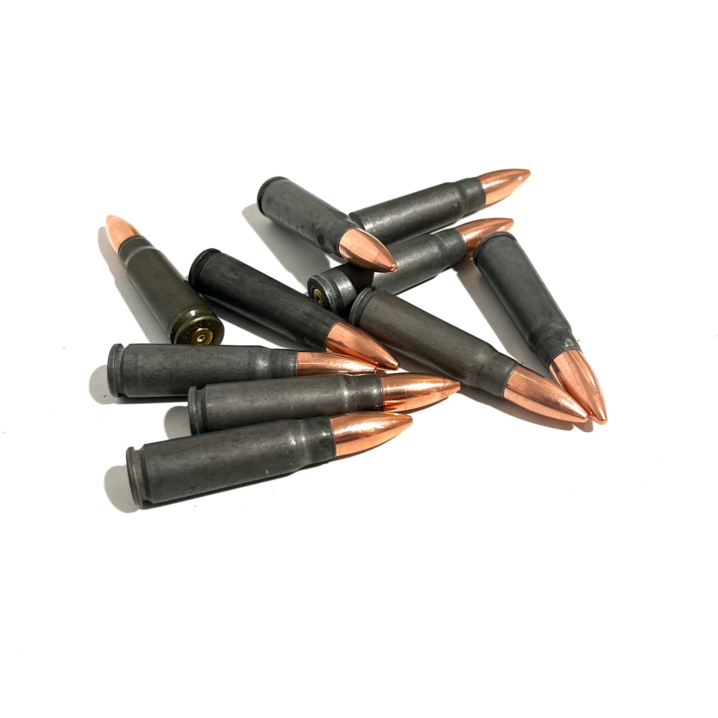A small jumbled pile of steel 7.62x39 dummy casings with copper bullets on a white background.