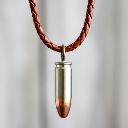 Authentic 9mm nickel dummy bullet casing fashioned into a pendant on a braided brown leather cord.