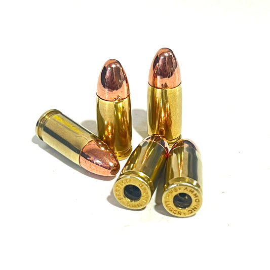 Four brass 9mm dummy rounds with copper bullets on a white background, showing Blazer and Winchester headstamps.