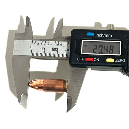 Digital caliper measuring a copper 9mm Luger dummy round's overall length at 29.48 millimeters
