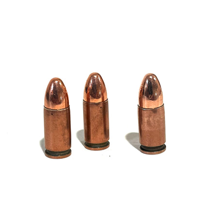 3 copper 9mm Luger dummy rounds standing upright on a white background