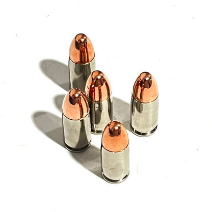 Five nickel 9mm dummy cartridges standing upright with round-nose tips facing up on a white surface.