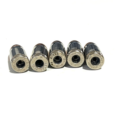 Five nickel 9mm casings lying on their sides, showing empty primer pockets and varied headstamps.