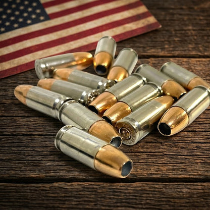  Inert 9MM Luger nickel dummy rounds arranged on a dark rustic barn wood surface with a vintage American flag in the background. Genuine once-fired casings.
