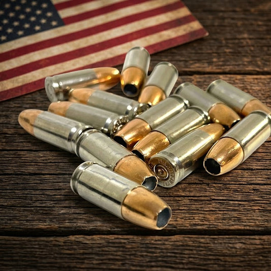 Inert 9MM Luger nickel dummy rounds arranged on a dark rustic barn wood surface with a vintage American flag in the background. Genuine once-fired casings.
