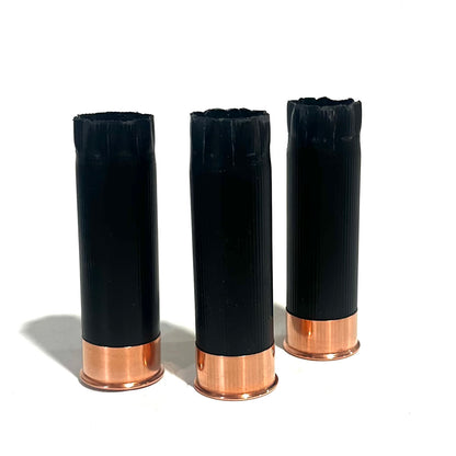 3 black shotgun shell hulls with copper bases viewed from open crimped end, star-shaped crimp pattern