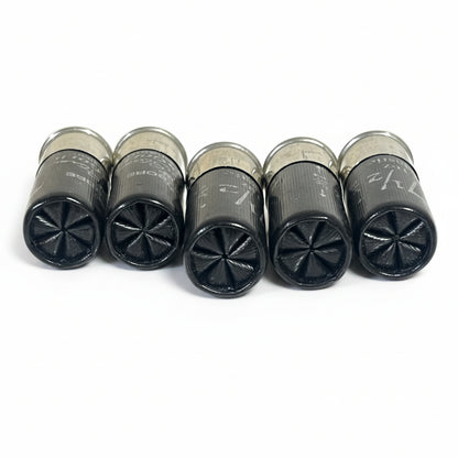 Five black spent shotshells lined up front-facing, showing their six-star crimped ends