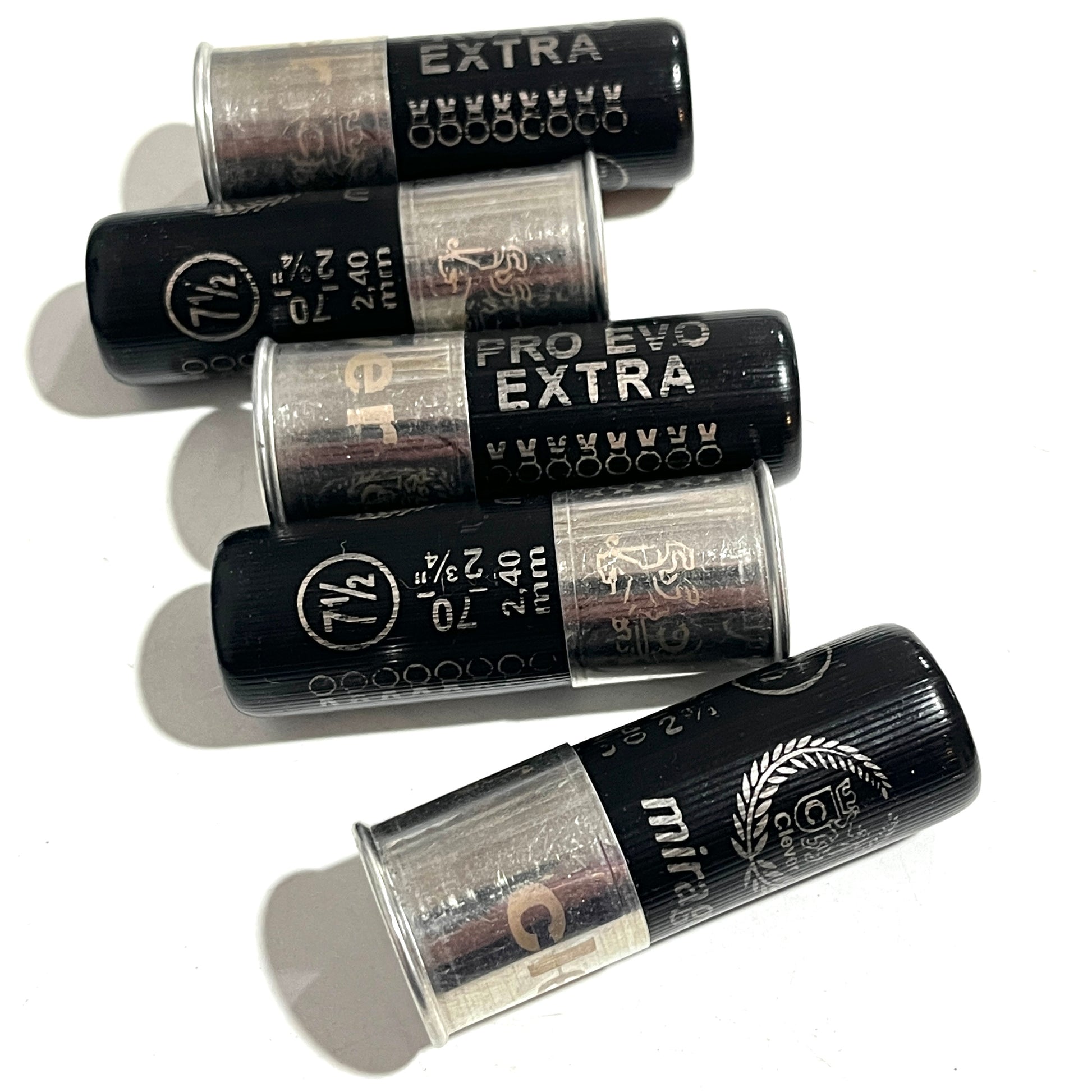 Five black 12-gauge shotgun hulls arranged diagonally, showing printed "PRO EVO EXTRA" text and crimped tops.