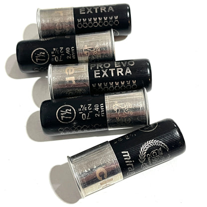 Five black 12-gauge shotgun hulls arranged diagonally, showing printed "PRO EVO EXTRA" text and crimped tops.