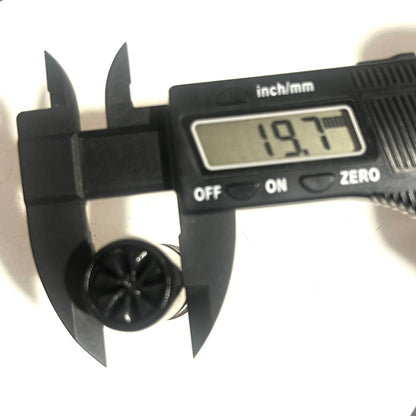 Digital caliper measuring the star-crimped top of a black 12-gauge dummy round, reading 19.7 mm.