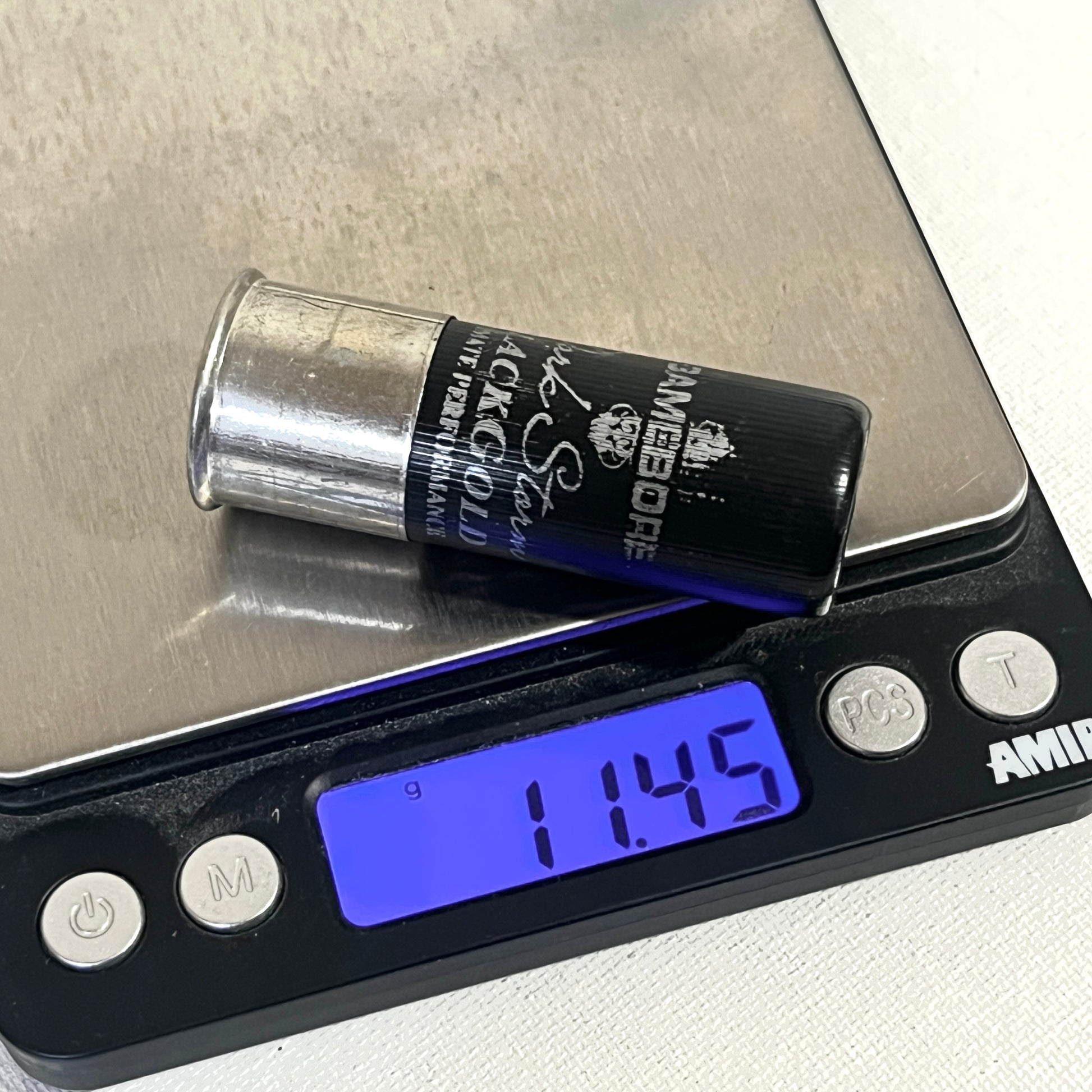 Black Gamebore fake shotshell on a digital scale reading 11.45 grams