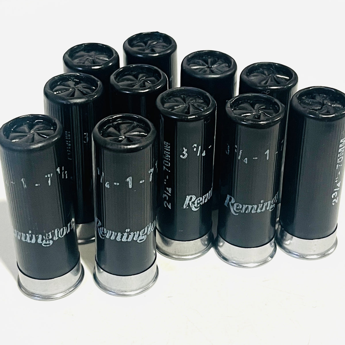 Used black Remington dummy rounds standing in a cluster, Remington lettering and silver bases visible