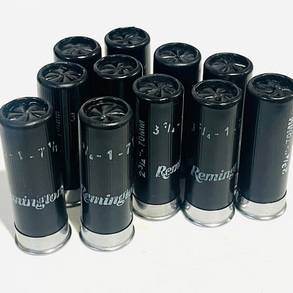 Used black Remington dummy rounds standing in a cluster, Remington lettering and silver bases visible