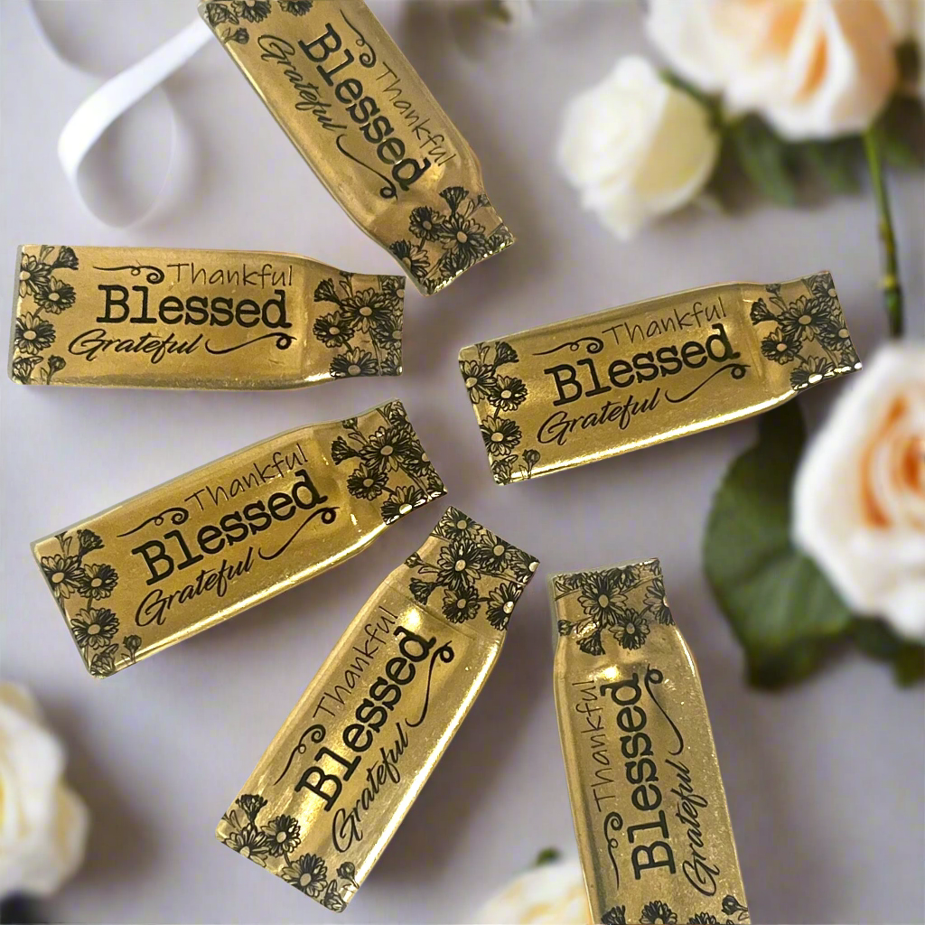 Six flattened .308 brass casings engraved with flowers and the words Thankful, Blessed and Grateful