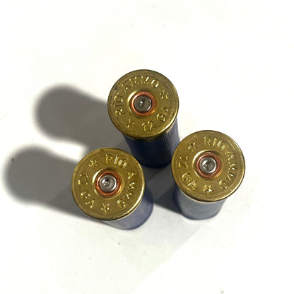 Overhead view of three blue 12 gauge dummy shotgun shells showing gold Rio Ammo headstamps