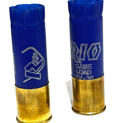 2 empty blue 12 gauge RIO shotgun shells with brass bases standing on a white background