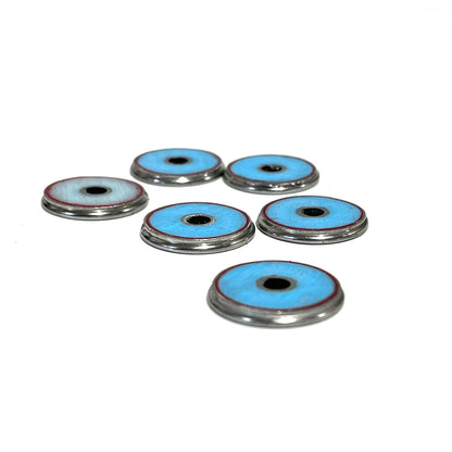 Six shotgun shell slices shown from the back, revealing turquoise-blue undersides with silver rims.