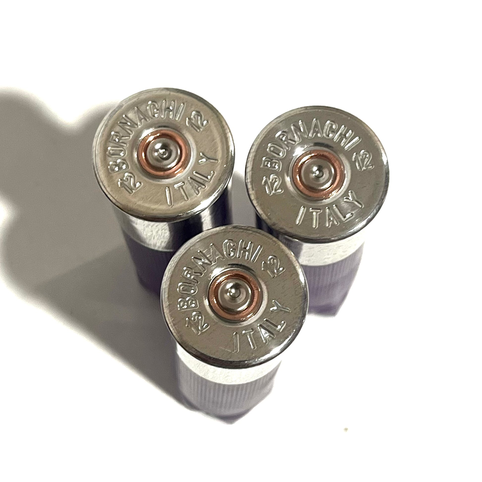 3 silver 12 gauge shotgun shell base caps stamped Bornaghi 12 Italy, viewed from above