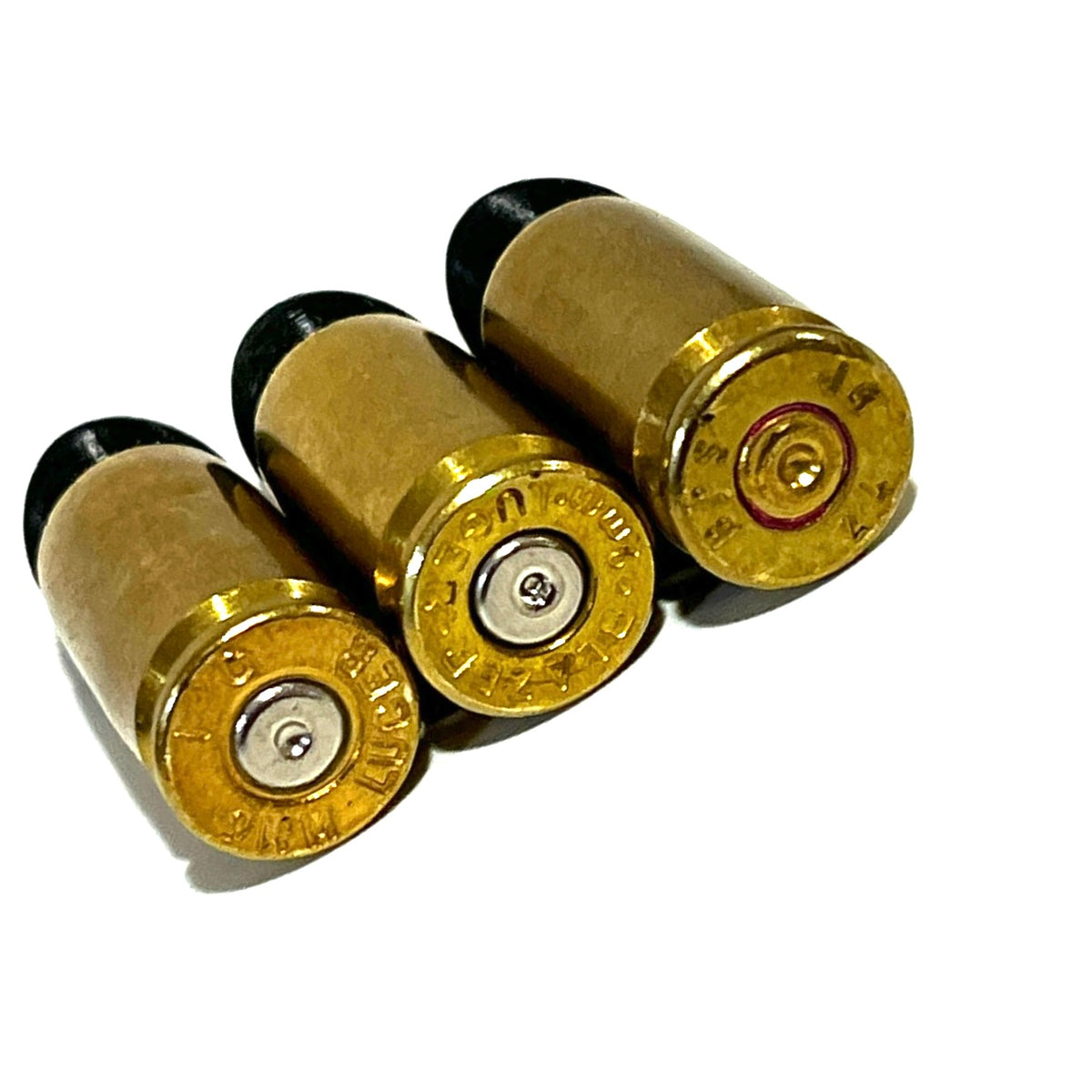 3 fake 9mm Luger dummy round brass bases viewed from behind showing mixed headstamp markings