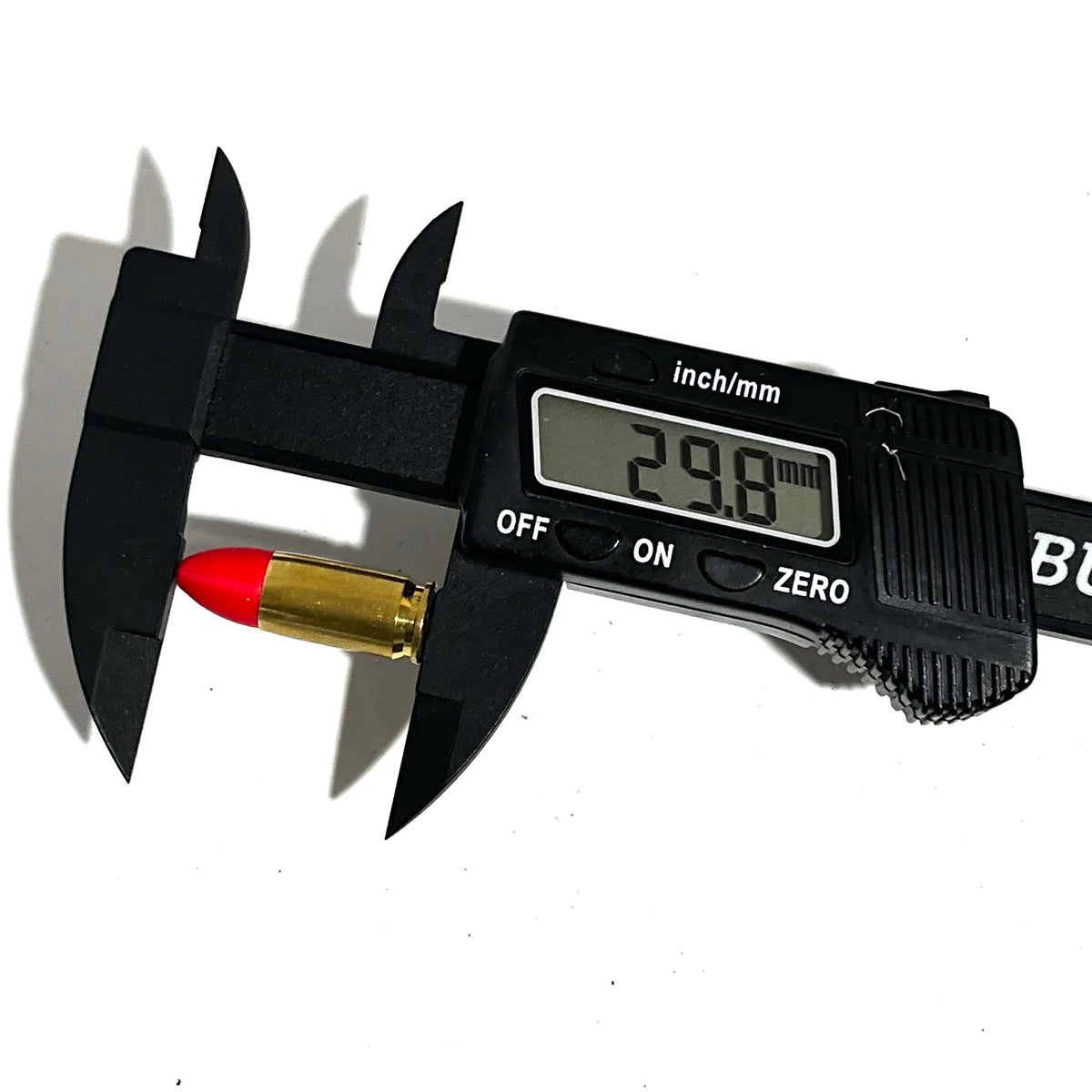 Digital caliper measuring the length of a fake 9mm Luger dummy round with red tip at 29.8mm