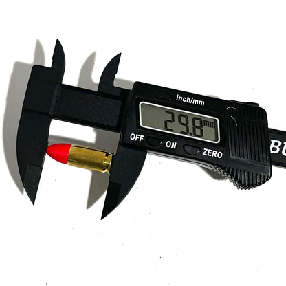 Digital caliper measuring the length of a fake 9mm Luger dummy round with red tip at 29.8mm