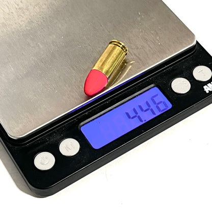 Fake 9mm Luger dummy round with red painted tip on a digital gram scale reading 4.46 grams