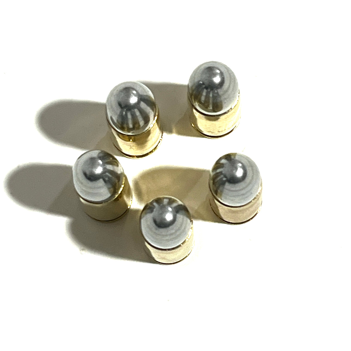 Five brass 9mm shells viewed from above, showing their rounded silver bullet tips and shadows.