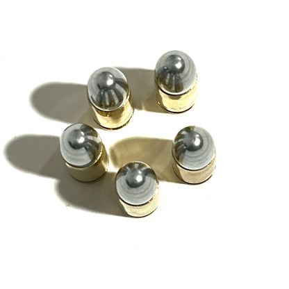 Five brass 9mm shells viewed from above, showing their rounded silver bullet tips and shadows.
