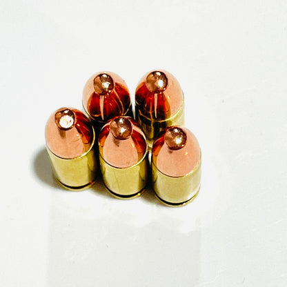 Five spent brass shells with copper round-nose bullets standing upright in a tight cluster, viewed from above