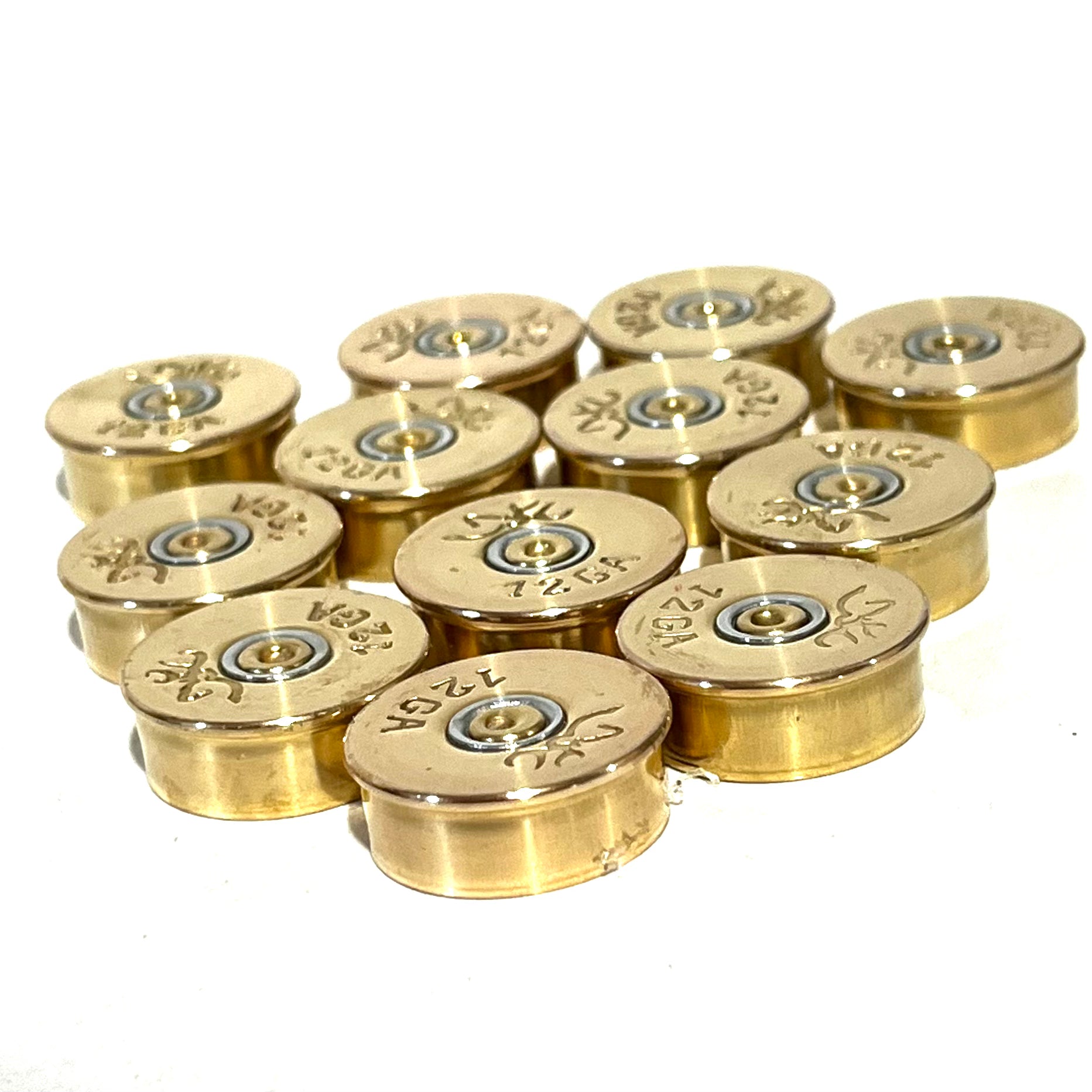 Twelve polished brass 12 gauge shotgun shell bottoms with Browning headstamps viewed at an angle