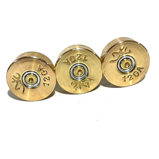 Three polished brass 12 gauge shotgun shell bottoms showing Browning deer logo headstamps
