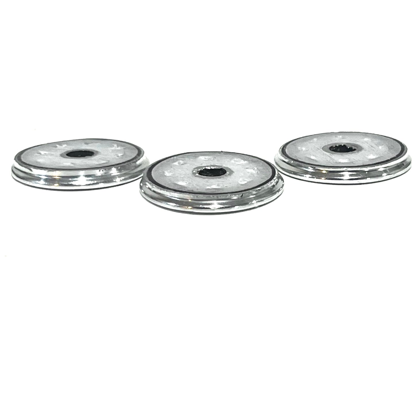 Side profile of three silver Browning shotgun shell slices showing thin edges and center openings