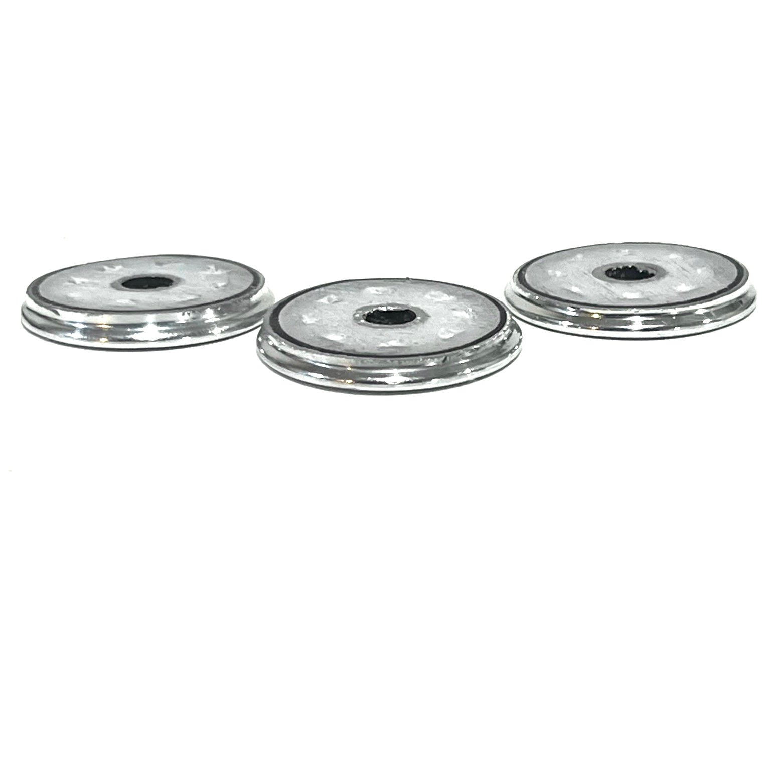 Side profile of three silver Browning shotgun shell slices showing thin edges and center openings