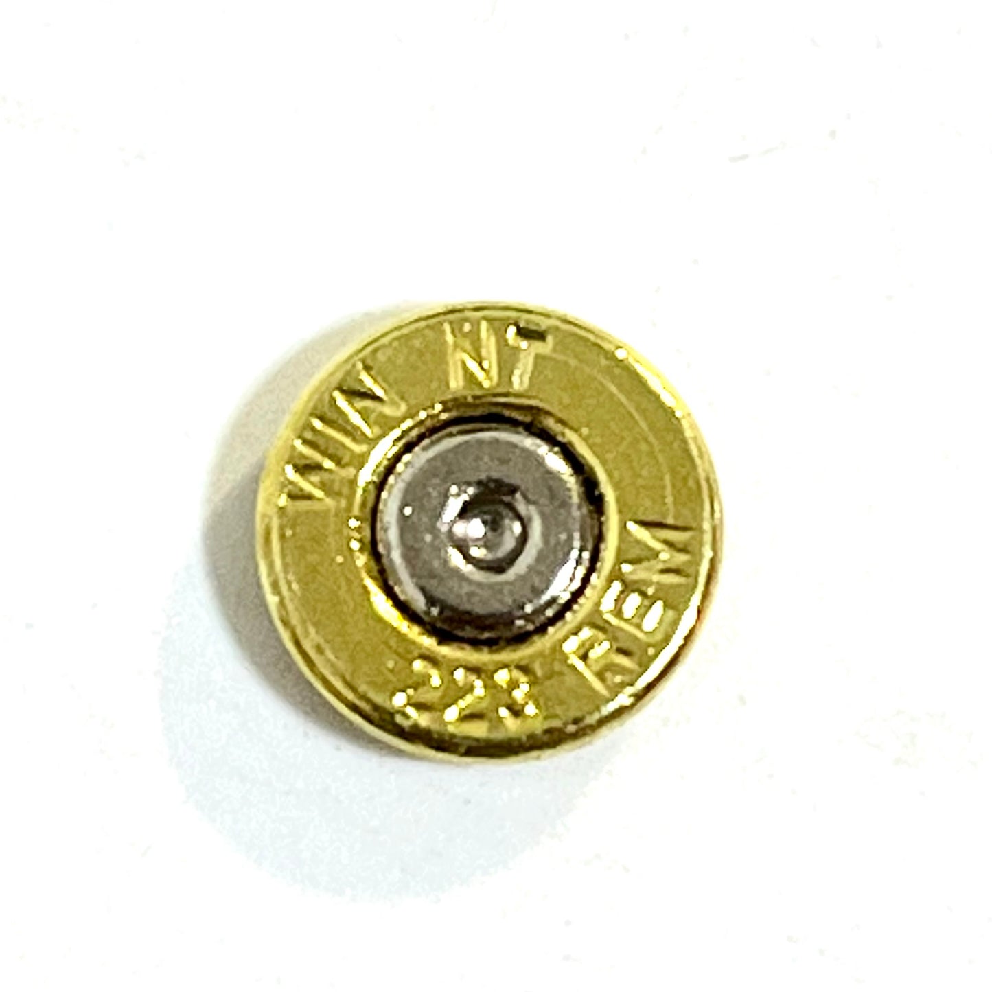 Close-up of a thin-cut polished brass 223 bullet slice measuring approximately 2mm thick.