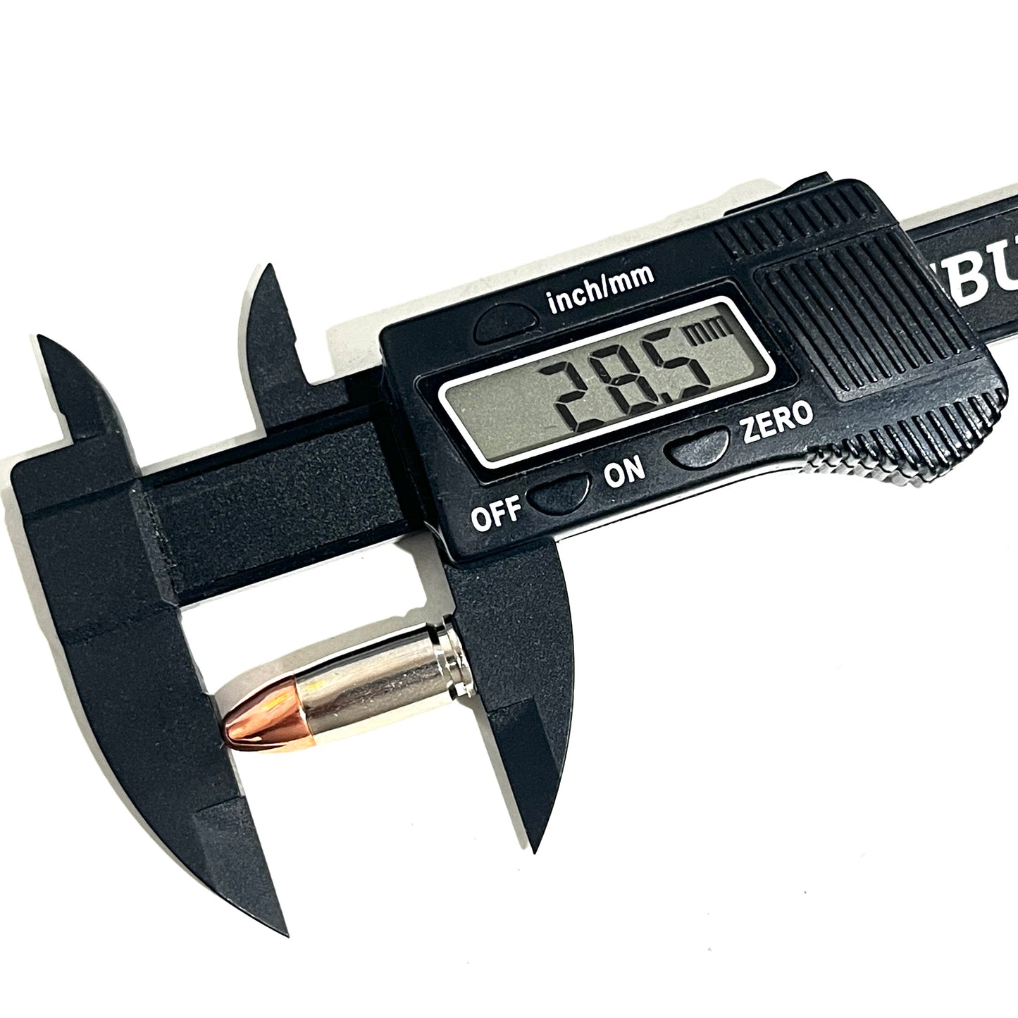 A black digital caliper measuring the overall length of a nickel 9mm dummy casing, reading 28.5 mm.