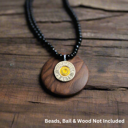 Nickel 45 ACP bullet slice pendant with gold primer on a wood disc and black beaded necklace, with text reading Beads, Bail and Wood Not Included