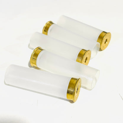 Five clear, empty 12 gauge casings lying diagonally on a white surface with their brass heads alternating end to end primer removed for diy christmas lights
