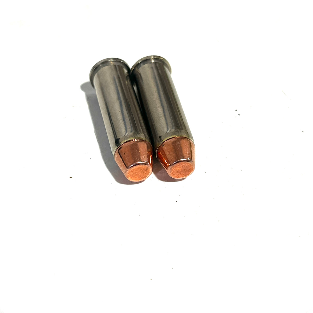 Two deprimed 9mm brass dummy rounds with copper round nose bullets side by side on a white background.