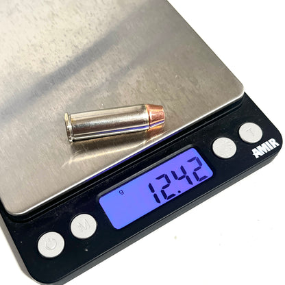 Nickel 38 Special dummy round with a copper flat nose bullet resting on a digital gram scale reading 12.42