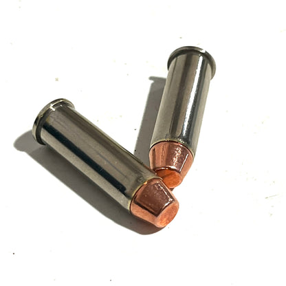 Two deprimed nickel 38 Special dummy rounds crossed with copper flat nose bullets on a white background.