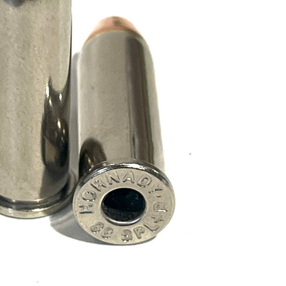 Close-up of a deprimed nickel 38 Special dummy round showing the Hornady headstamp on a white background.