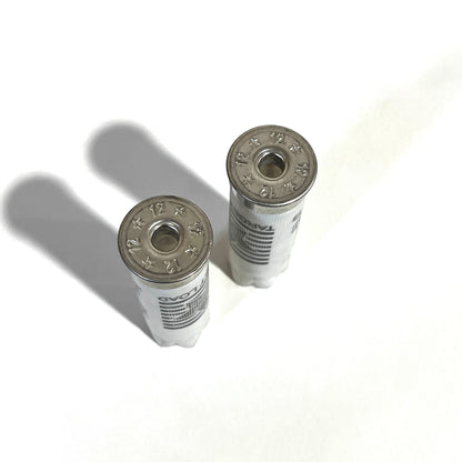 Two deprimed white Stars and Stripes 12 gauge shotgun shells viewed from above showing empty primer holes