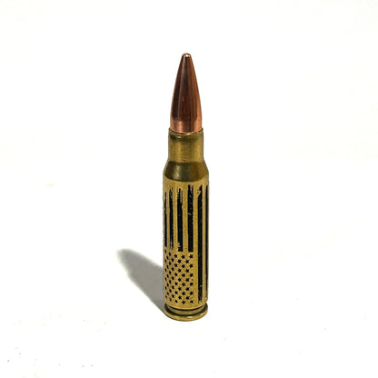308 Win dummy round featuring a vertical distressed American flag engraving on authentic once-fired brass casing.
