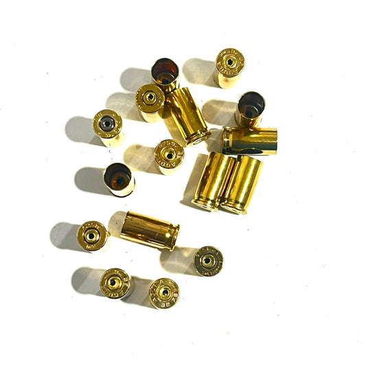 Scattered pile of drilled .32 Auto brass shells showing AGUILA headstamps and open mouths
