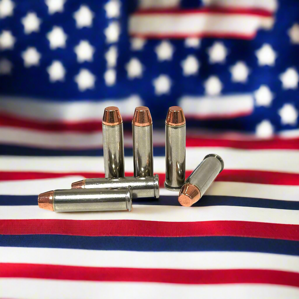 Five nickel fake bullets arranged on an American flag background with three standing upright and two lying down.