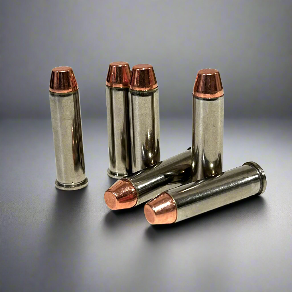 Five nickel display cartridges with copper flat nose bullets, three standing upright and two lying down on a reflective gray background.