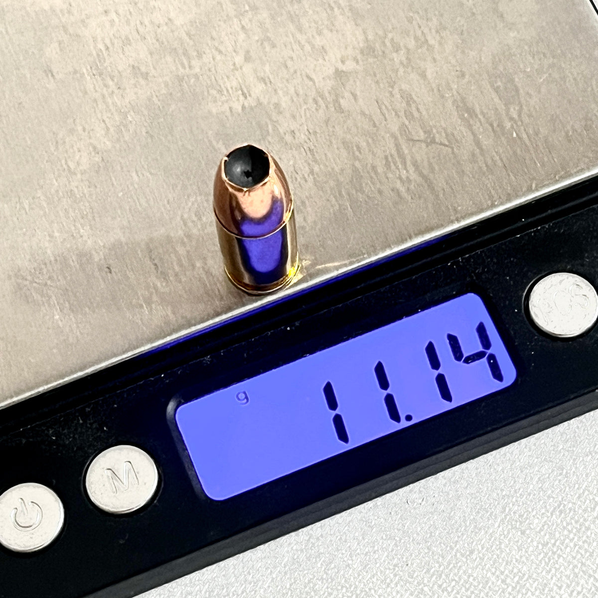 Single dummy .380 Auto round on a digital gram scale reading 11.14 grams