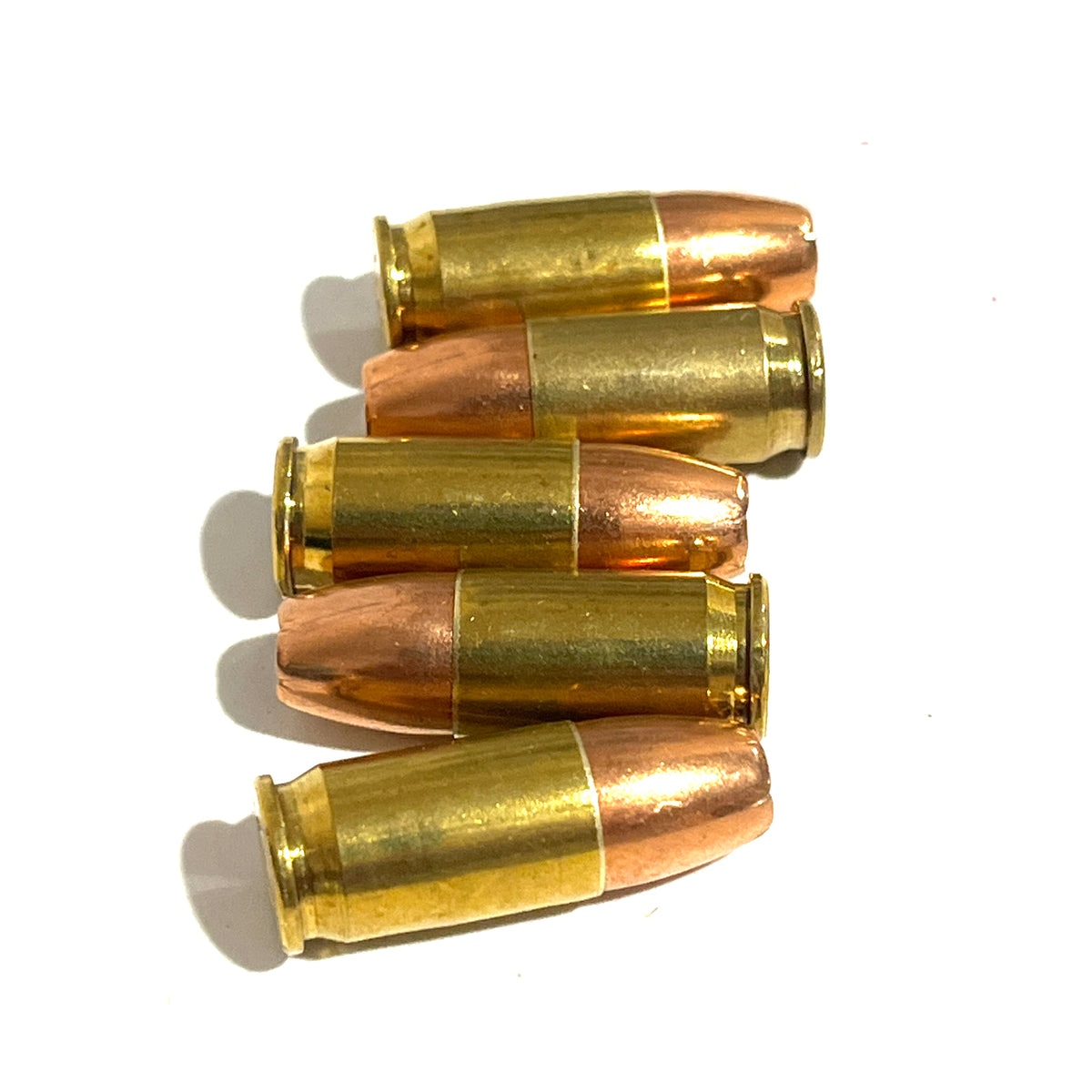 5 dummy .380 Auto rounds laid horizontally in staggered rows on white background, brass casings and copper bullets